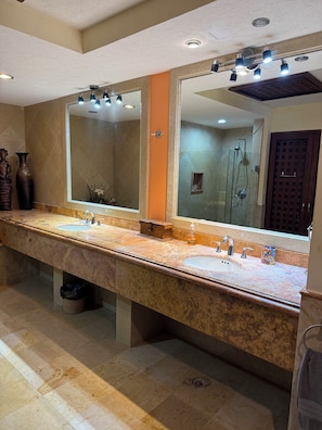 Un bagno ampio con due lavabi, un grande specchio e una doccia.