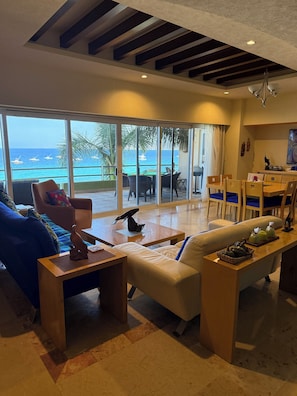 Un soggiorno moderno con vista sul mare, una zona pranzo e una cucina.