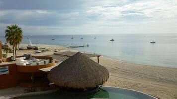 Een resort met zwembad, strand en uitzicht op de oceaan.