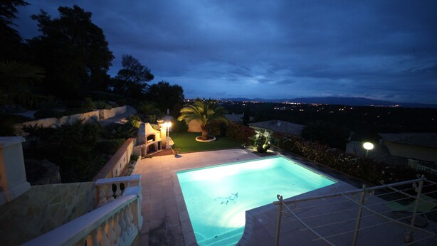 A swimming pool with a view of the city at dusk.
