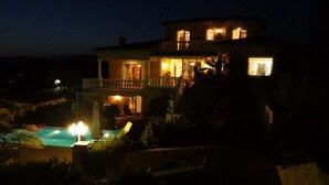 A two-story house with a balcony and a swimming pool.