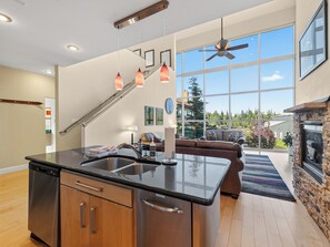 A modern kitchen with a central island, stainless steel appliances, and pendant lighting.