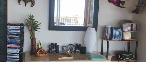A room with a wooden desk, bookshelves, and decorative fish on the wall.
