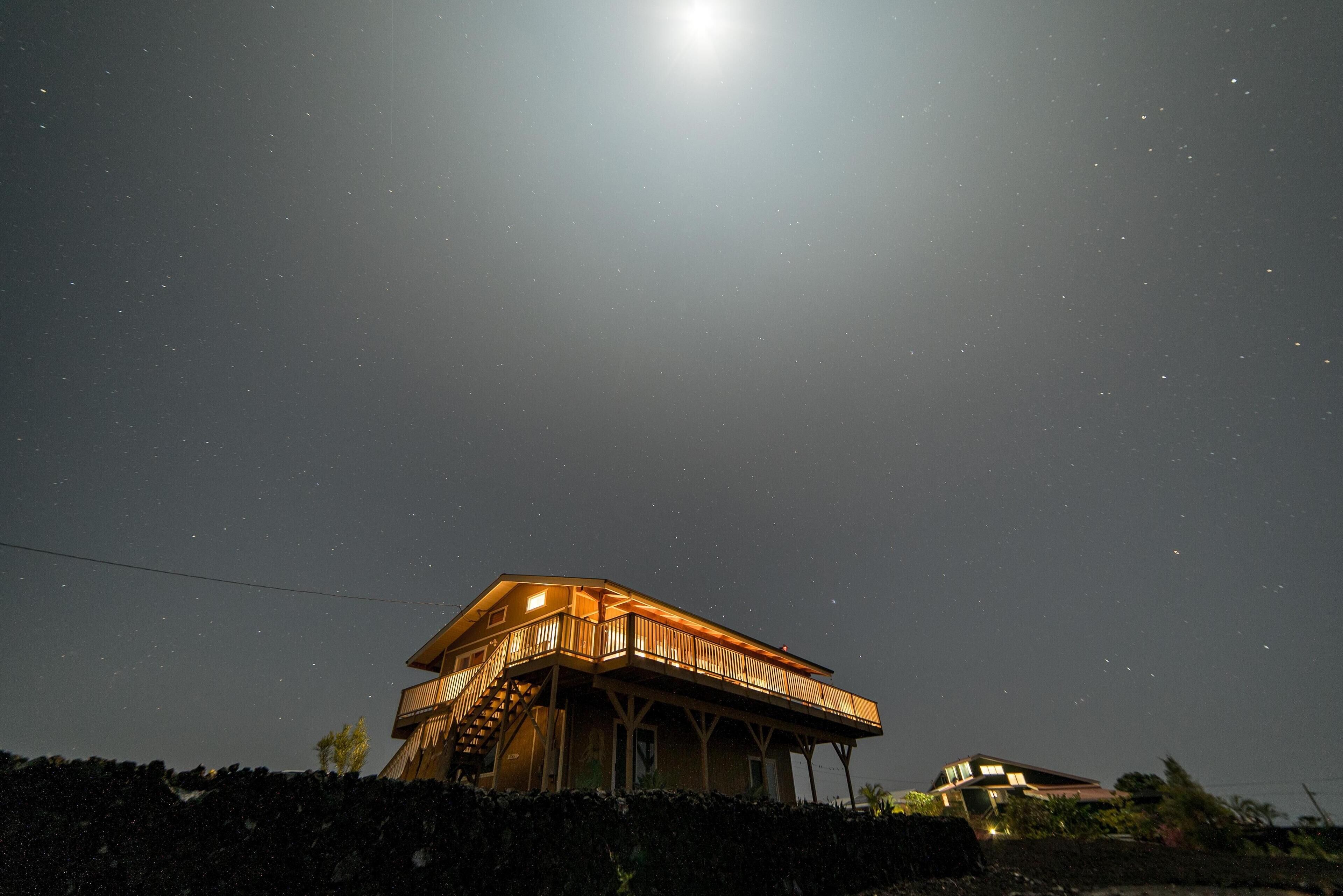 A house with a balcony under a starry night sky.
