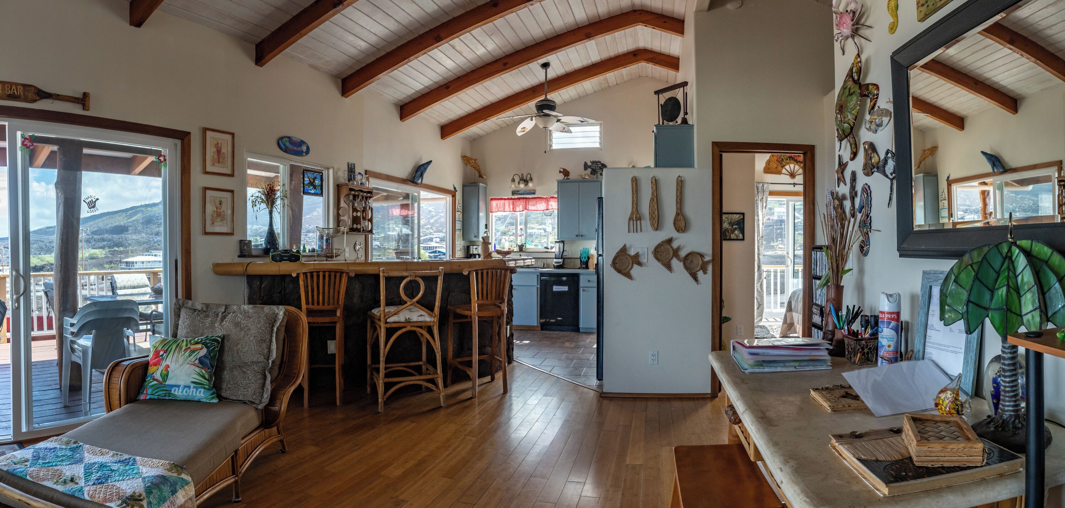 Une cuisine spacieuse avec un plancher en bois, un coin bar et un espace repas offrant une vue agréable.
