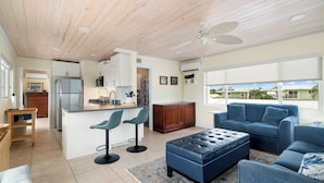 A modern kitchen with a central island, bar stools, and a blue leather ottoman. - Nov 18-Jan 1 Open... Live Like a Local*Waterview*Pet Friendly*Key Largo MM 99.5*Manatees (Key Largo)