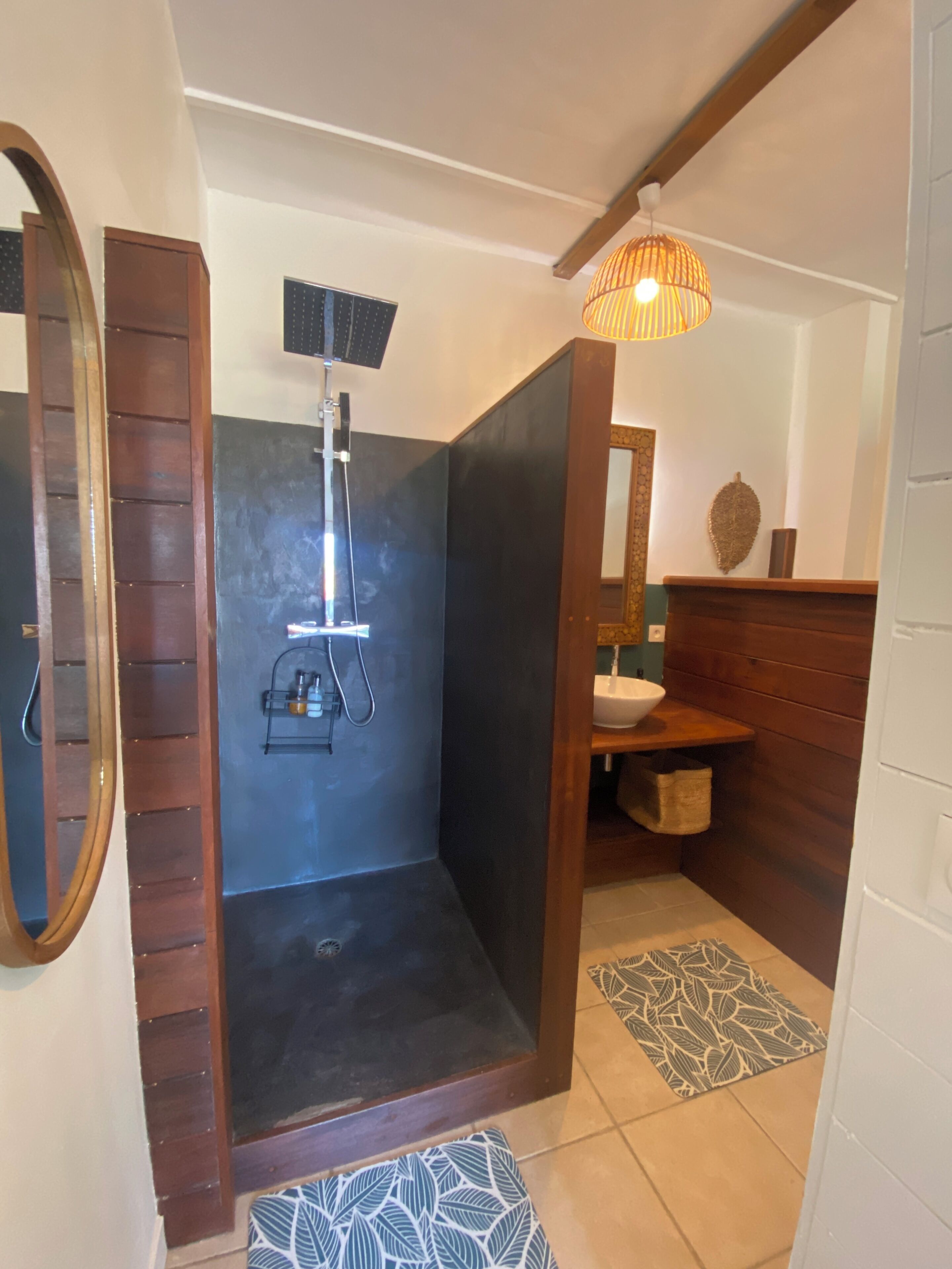 A bathroom with a shower, a sink, and a mirror.