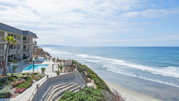 Un hôtel situé en bord de mer, doté d’une piscine, d’un jardin aménagé et offrant une vue sur l’océan.