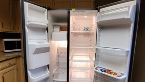Una cocina moderna con refrigerador empotrado, microondas y armarios de madera.