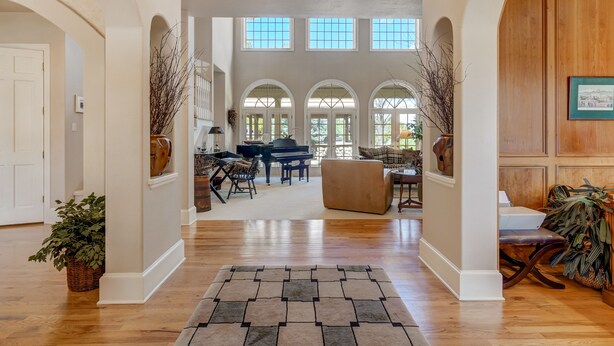 A spacious living area with a piano, sofas, and a large window. - Broadmoor Estate Summer Rental - Designed for unforgettable family getaways. (Colorado Springs)