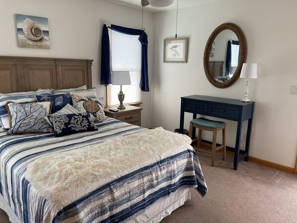 A bedroom with a large bed, a desk, a chair, a mirror, and a window with curtains. - Spacious home,saltwater heated pool, game room, volleyball,ocean views & Tennis (Corolla)