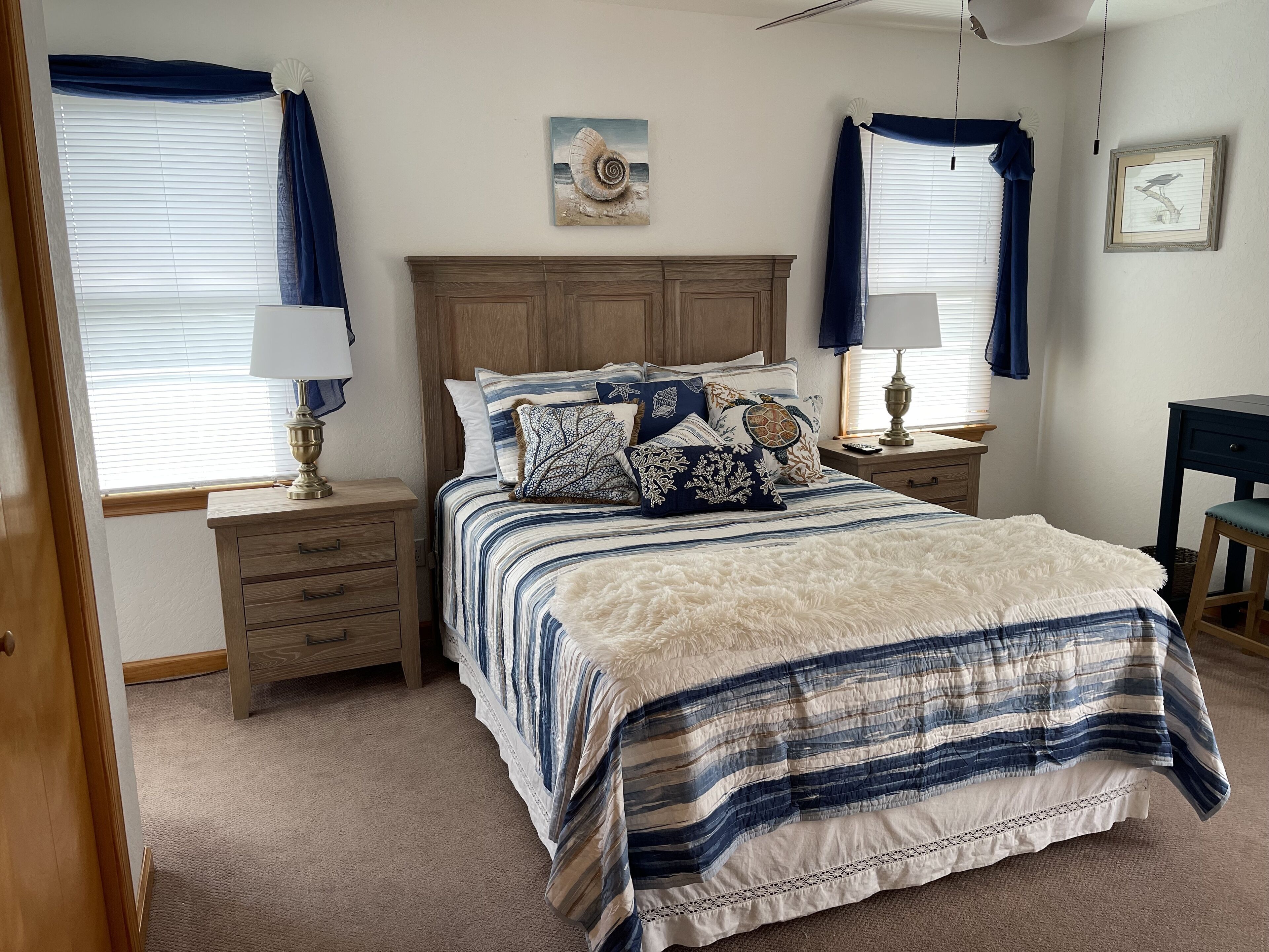 A bedroom with a bed, two nightstands, a desk, and a chair.