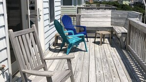 A wooden deck with two Adirondack chairs and a small table. - Spacious home,saltwater heated pool, game room, volleyball,ocean views & Tennis (Corolla)