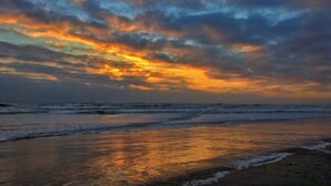 A beach with waves and a sunset sky. - Spacious home,saltwater heated pool, game room, volleyball,ocean views & Tennis (Corolla)