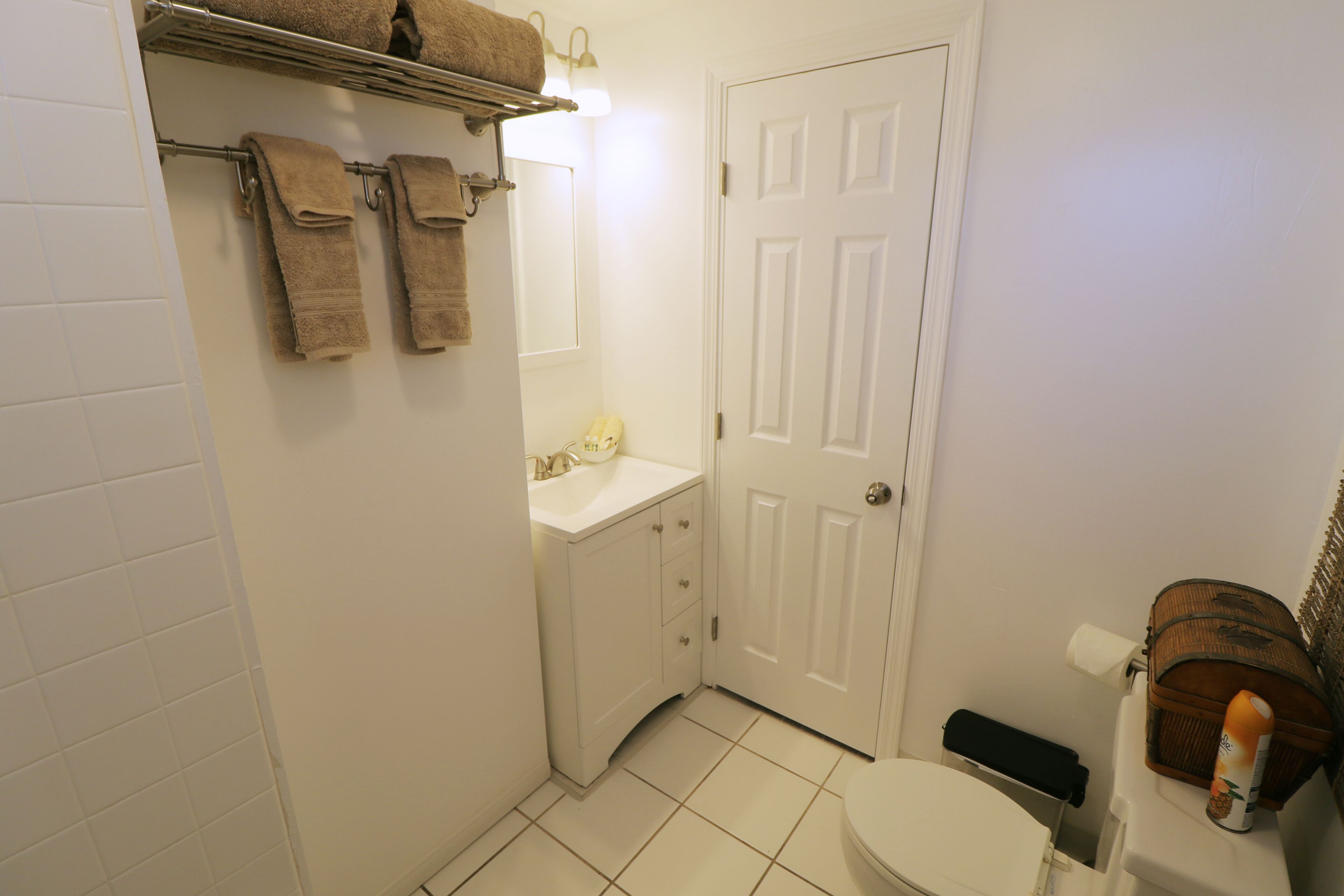 Une salle de bain équipée de toilettes, d’un lavabo et d’un porte-serviettes.