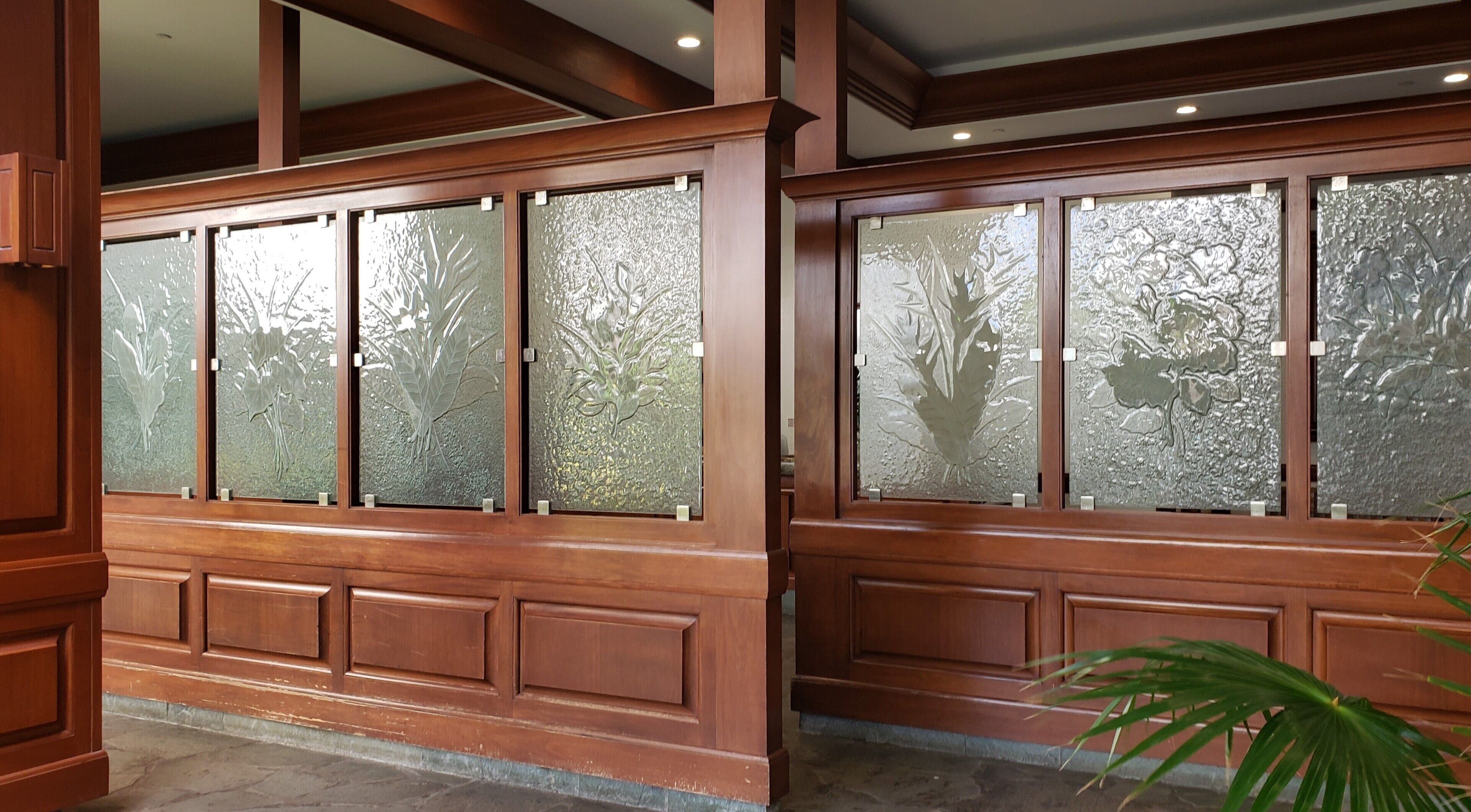 Conjunto de ventanas con marcos de madera y paneles de vidrio satinado con diseños florales en relieve.