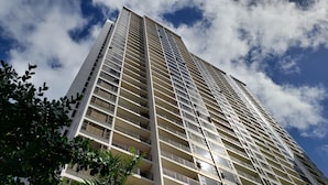 Un edificio alto y moderno con varios balcones y ventanas amplias.