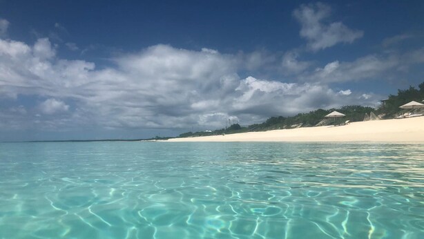 A beach with clear turquoise water and a white sandy shore.