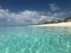 A beach with clear turquoise water and a white sandy shore.