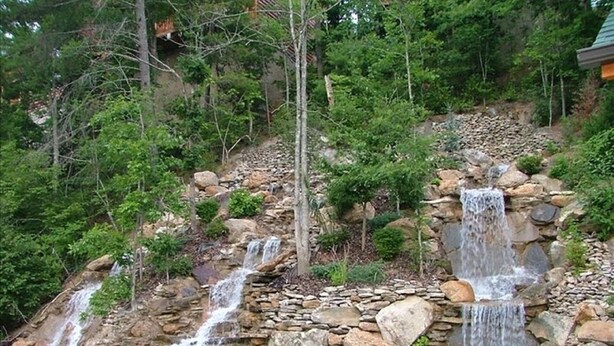 Un paysage naturel caractérisé par de nombreuses cascades dévalant un terrain rocheux, le tout étant entouré d’une végétation luxuriante.
