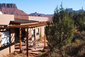 A building with a patio area featuring outdoor furniture and a pergola.