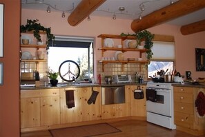 Kitchen with a central island, stainless steel sink, and a window offering a view of the outdoors.