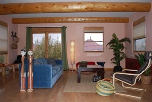 Relax in this inviting living space with a sofa, floor lamp, and scenic mountain view.