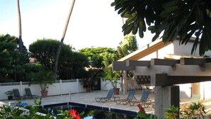 Ein Poolbereich mit Liegestühlen, einer Pergola und Kübelpflanzen.