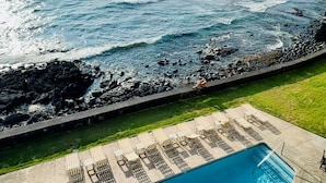 Una piscina con vista al océano y a la costa rocosa.