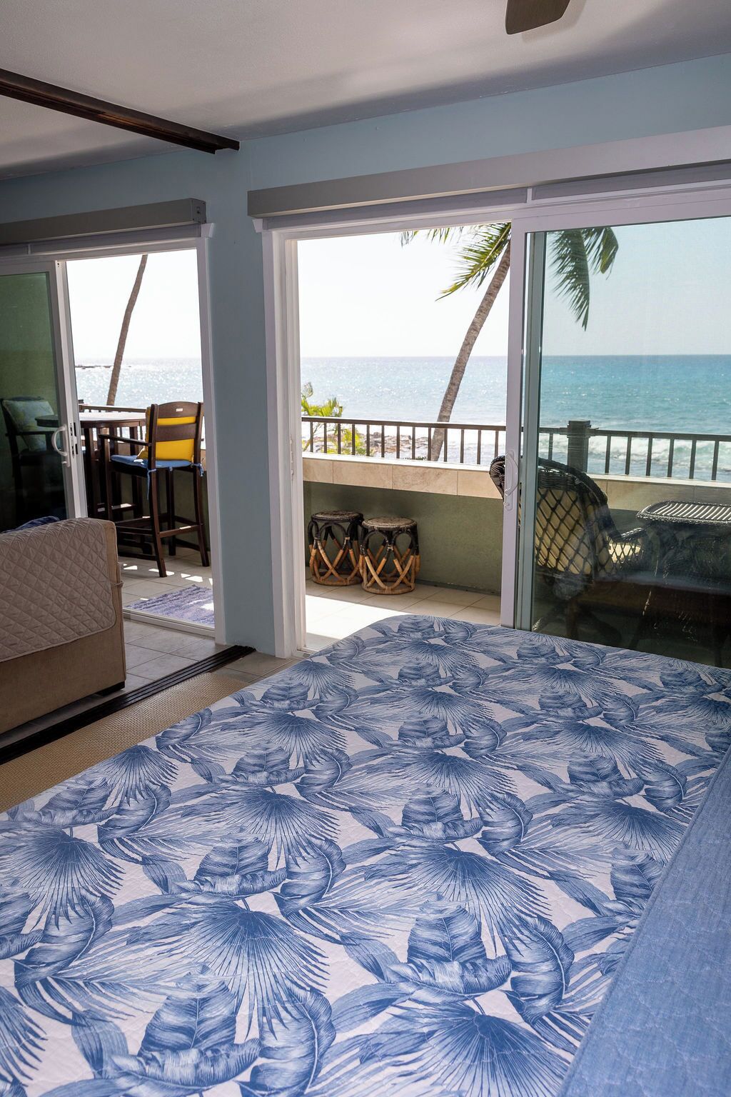 Ein Zimmer mit Bett, Meerblick und Balkon mit Sitzmöglichkeiten.