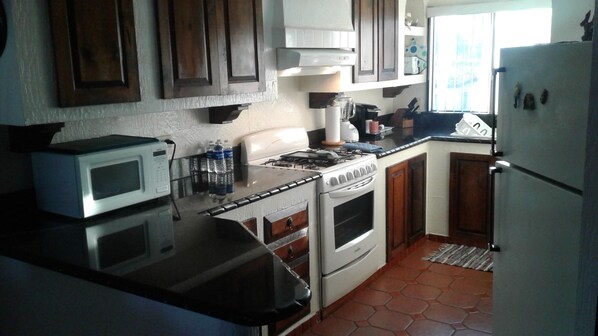 A kitchen with a stove, microwave, and refrigerator. - Gated Community with Oceanview Villas - Sandy Beach Access - Great Location! $99 (Rosarito Beach)