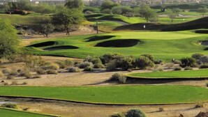 A golf course with a mountainous backdrop.