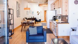 A modern living room with a sofa, a dining area, and a kitchen. - Downtown Luxury Loft- Enjoy the Mountains in the Heart of Downtown Estes Park (Estes Park)