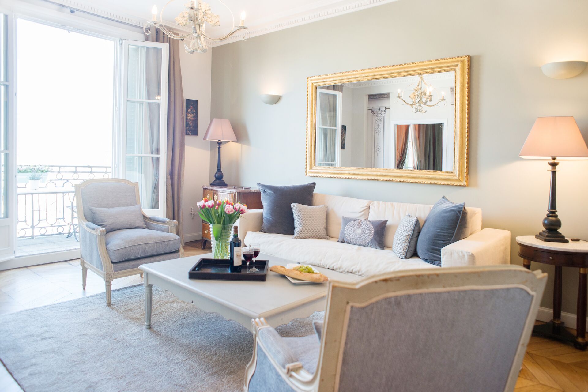Een woonkamer met een bank, fauteuil, salontafel en een grote spiegel.