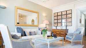 A living room with a sofa, two armchairs, a coffee table, and a decorative mirror. - Dream-Come-True With Breathtaking Eiffel & Paris Views + Terrace (Paris)