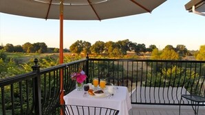 A balcony with a table set for breakfast, featuring a white tablecloth, a vase of flowers, and a view of a green landscape. - AUBURN COTTAGE POOL HOUSE, SPA AND GROUNDS G & Christmas Now Open 5 day min (Auburn)