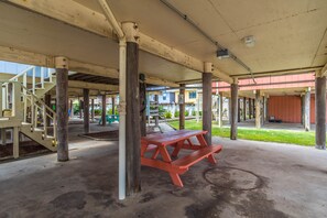 An outdoor covered area with picnic tables, concrete flooring, and a staircase leading to an upper level. - 2 Bedroom, Across the street from the beach! & Pup-Friendly! (Gulf Shores)
