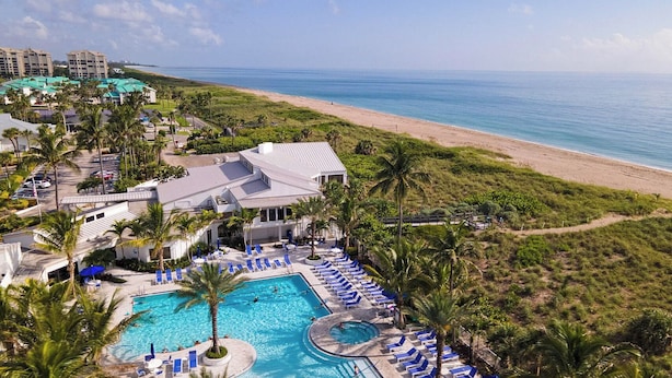 A resort with a large pool area, beach access, and multiple buildings. - Luxury Ocean Village Beach Condo with 5 Star Reviews with Wifi and all Extras (Fort Pierce)