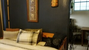 A bedroom with a bed, a wooden headboard, a framed picture, a wooden column, and a window with blinds. - VRBO 184287 Book Group trip Late Spring/Summer! We're Booked (Galveston)