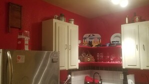 A kitchen with white cabinets, a refrigerator, and a red countertop. - VRBO 184287 Book Group trip Late Spring/Summer! We're Booked (Galveston)