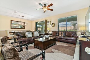 A living room with a brown leather sofa, a wooden coffee table, and a ceiling fan. - ⭐⭐⭐⭐⭐Oversize Private Pool & Spa, Free Pool Heat, Exclusive Luxury Platinum Home (Davenport)