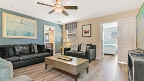 A living room with a black leather sofa, a wooden coffee table, and a ceiling fan. - ⭐⭐⭐⭐⭐Oversize Private Pool & Spa, Free Pool Heat, Exclusive Luxury Platinum Home (Davenport)
