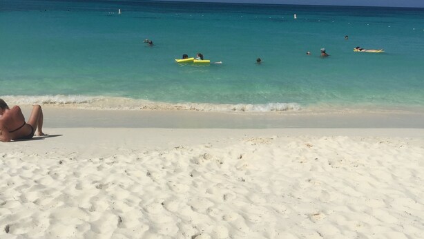 Una playa con arena blanca y agua turquesa cristalina.