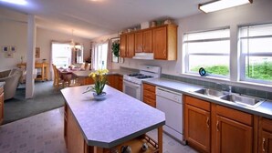 Una cocina moderna con armarios de madera, una isla central y vistas a zonas verdes.