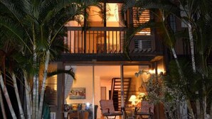 A two-story building with a balcony and a staircase leading to the upper level.