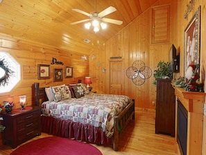 A cozy wooden room with a bed, a nightstand, a dresser, and a ceiling fan. - Stunning Mtn View/Dollywd Nightly Fireworks Seen On Deck Jun 15 - Aug 2/Hot Tub (Pigeon Forge)