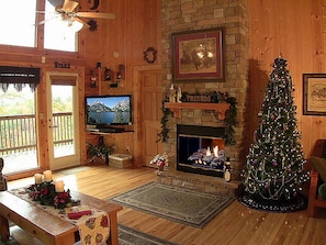A cozy living room with a fireplace, a television, and a Christmas tree. - Stunning Mtn View/Dollywd Nightly Fireworks Seen On Deck Jun 15 - Aug 2/Hot Tub (Pigeon Forge)