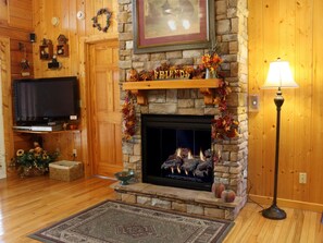 A cozy living room with a stone fireplace, a television, and a lamp. - Stunning Mtn View/Dollywd Nightly Fireworks Seen On Deck Jun 15 - Aug 2/Hot Tub (Pigeon Forge)