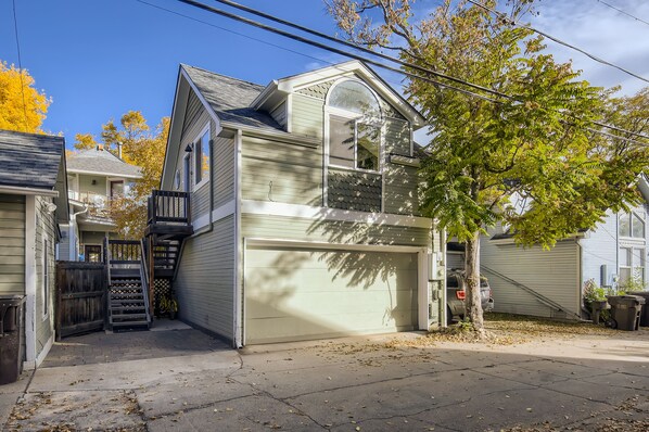 A two-story house with a garage, a front yard, and a tree.