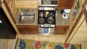 Enjoy cooking in this kitchen with a stainless steel sink, double-burner stove, and microwave.